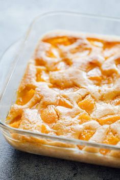 a casserole dish filled with peach cobbles on top of a gray counter