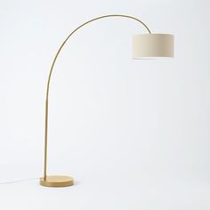 a floor lamp with a white shade on the base and a light bulb attached to it