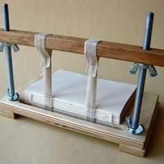 a wooden stand with two pieces of paper tied to it and some nails sticking out of them