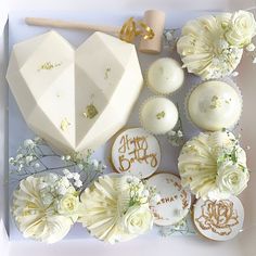 a white box filled with lots of different types of cakes and cupcakes on top of each other