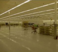 an empty warehouse with lots of shelves and carts