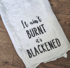 a white towel with black writing on it that says, it isn't burnt it is blackened