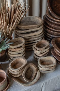 a table topped with lots of wooden bowls and plates