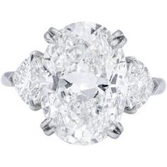 an oval cut diamond ring with three pear shaped diamonds on the shoulders and side stones