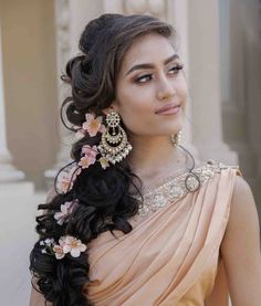 a woman with long hair in a dress and earrings on her head, posing for the camera