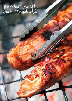 two pieces of meat being cut on top of a grill with tongs in it