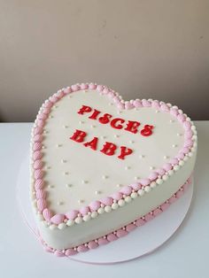 a heart shaped cake with the words pizza's baby written on it, sitting on a table