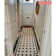 a hallway with black and white tile flooring next to a door in a house