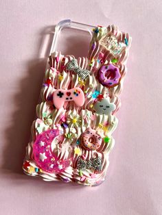 a cell phone case with an animal and donuts design on the front, sitting on a pink surface