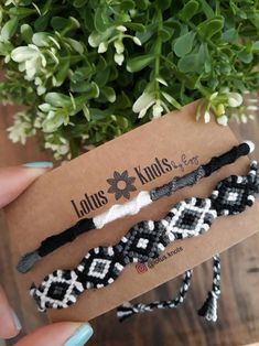 three braided hair ties sitting on top of a wooden table next to a potted plant