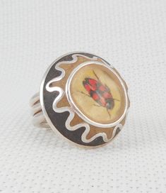 This OOAK artisan insect ring is a size 8 (or maybe a tad bigger) is an artisan created ring with 3 sterling bands that measure 1/4 all the way around the top of the ring is round with a rare black and red weevil and measures 1 inch in diameter the sides are scalloped with inset black and sand colored stone of some kind---not sure is not marked that I can see, but that is not unusual for artisan rings tests positive for sterling silver and is guaranteed in excellent condition great gift for an e Bug Ring, Insect Ring, Artisan Rings, Colored Stone, Tucson, Sterling Ring, Rings Statement, Bugs, Insects