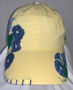 "Good Morning, Glory" women's adjustable ball cap shown in yellow. This baseball cap features beautiful clusters of morning glories that have been wood burned, and then precision dyed and painted by hand. The unique stitching and handmade charm make this cap a must-have for all the morning people out there. Available in yellow (shown), lavender, pink and white. Please note that charms may vary from what is shown depending on supply. ALL designs are fully customizable; Personal color options may be made-to-order. Custom orders can take up to two weeks to create.  Email SouthernSunshineCustoms@gmail.com with any questions, or to discuss custom order options.  Return Policy We will accept returns of item if notified within 14 days. Buyer to pay all costs associated with return shipping. Funds Casual Hand Painted Cap, Yellow Cotton Trucker Hat With Curved Brim, Yellow Adjustable Visor Dad Hat, Adjustable Yellow Dad Hat Visor, Yellow Dad Hat For Summer, Casual Hand Painted Hat, Yellow Dad Hat Baseball Cap For Summer, Casual Yellow Baseball Cap For Spring, Yellow Adjustable Dad Hat For Spring