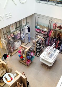 the inside of a clothing store with clothes on display