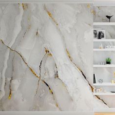 a white marble wall with shelves in the background