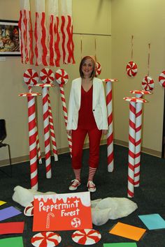 a woman is standing in front of candy canes