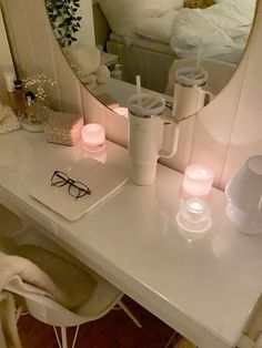 a white vanity with candles and glasses on it