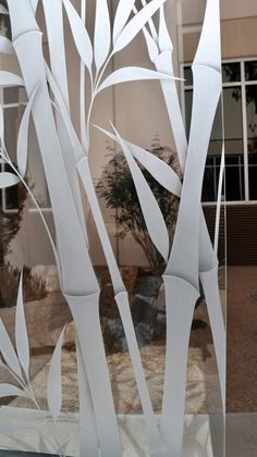 a glass window with white leaves on it