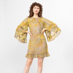 Vintage late 60s mini party dress in a gorgeous yellow and blue paisley print. It has a super flowy tent cut and statement bell sleeves. There are a few condition notes, please review photos and details below before purchasing. The dress has been laundered and is ready to wear. Measurements and Condition: Fits like: Women's extra small to petite small Fabric: Feels like a sheer gauzy cotton shell with a fitted polyester lining Brand: Ingenue California Juniors Condition: Fair, with a 3/4" hole and a thin horizontal snag line on the lower front of the skirt with a 1" faded spot in the print next to it, a section of scattered tiny holes and small faint dark spots on the front right waist, and some other scattered tiny holes/minor snags. There are some discolorations on the inside lining that Yellow Paisley Print Spring Dress, Long Sleeve Paisley Print Patterned Dress, Multicolor Paisley Print Long Sleeve Dress, Vintage Paisley Print Dress, Bell Sleeve Mini Dress, Patterned Paisley Print V-neck Dresses, Hippie Dress, Mini Party, Hippie Dresses