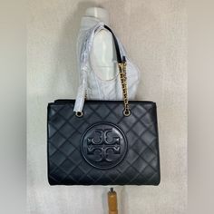 Fast Shipping. Arrive In 2-3 Business Days. Soft Fleming Chain Tote By Tory Burch. This Bag Is Made Of Black Quilted Soft Genuine Leather Dimensions: 13.8” Wide X 10.4” Tall Center X 5" Deep. Double Partial Chain Straps With 9.5" Drop. Magnetic Snap Button Closure Interior: 1 Open Pocket And 1 Zippered Pocket Fabric Lining. Gold Tone Metalware. Comes With Dust Bag. Tory Burch Soft Fleming, Tory Burch Kira Chevron, Ella Tote, Gold Tote Bag, Kira Chevron, Slouchy Tote, Tory Burch Purse, Tory Burch Tote, Tory Burch Bag Totes