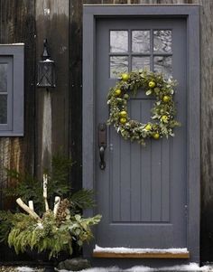 a gray front door with a wreath on it