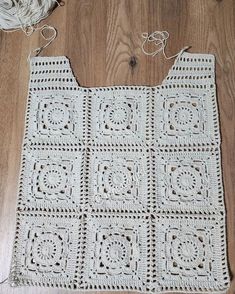 a white crocheted bag sitting on top of a wooden floor