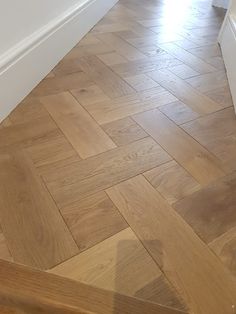 an empty room with hard wood flooring and white walls