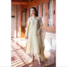 A Luscious Composition Is Layered Over This Exquisite Ensemble Rendered In A Classy Yellow Beige Shade. It Features A Classy Silhouette Shirt Adorned With Intricate Embroidery With Aesthetically Rich Floral Designs. Paired With A Contemporary Shalwar Enriched With Delicate Embroidery At Bottom Opening And A Gracefully Embroidered Dupatta With Aesthetically Rich Floral Designs, This Fashion Statement Outfit Will Let You Look Gorgeous At Festive Occasions. -Yellow Beige Color -Fabric: Lawn (Shirt Fashion Statement Outfits, Embroidered Suit, Statement Outfit, Delicate Embroidery, Yellow Beige, Embroidered Dupatta, Lawn Shirts, Organza Dupatta, Intricate Embroidery