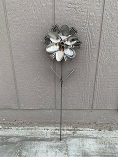 a metal flower on the side of a building