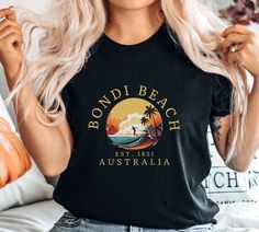 Bondi Beach Shirt,  Sydney Australia T shirt, Australia T shirt,  Crewneck Unisex Australia Gift, Bondi Beach Unisex Crewneck Shirt This Bella Canvas unisex jersey short sleeve tee fits like a well-loved favorite. Super soft cotton, high quality fabric and quality print. - 100% Airlume combed and ringspun cotton (Only heather colors are 52% cotton, 48% polyester - Athletic Heather is 90% cotton, 10% polyester) - Light fabric - 4.2 oz/yd² (142 g/m²) - Retail fit - Runs true to size - Incredibly s Crew Neck Shirt With Letter Print For Vacation, Black Crew Neck Top For Vacation, Crew Neck Surfing Tops For Vacation, Vacation Crew Neck Shirt With Letter Print, Black T-shirt With All Over Print For Beach, Surfing T-shirt With Front Print For Beach Season, Hawaiian T-shirt For Surfing Beach Season, Cotton Surfing T-shirt For Vacation, Tropical T-shirt For Beach Season Surfing