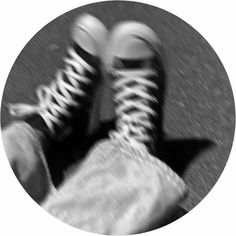 a black and white photo of someone's feet with sneakers on top of them