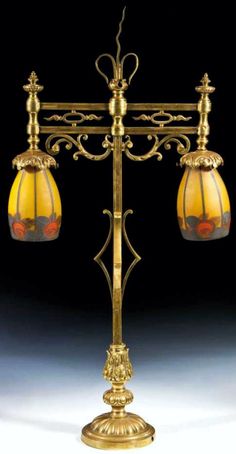 an ornately designed lamp with two lamps on it's sides and one light hanging off the side