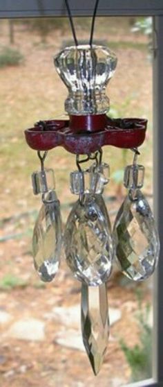 a bird feeder hanging from the side of a window sill with three wine glasses on it