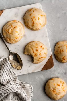 orange glazed cookies on a marble board with a spoon