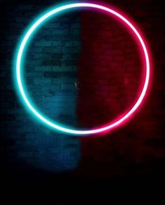 a red and blue neon circle on a brick wall in front of a black background