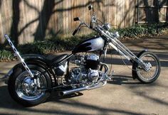 a black motorcycle parked in front of a wooden fence