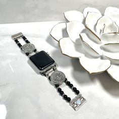 Chic beaded Apple iWatch band. Features Black and silver toned beads with crystal accents and a magnetic clasp for easy wear. Sizing Options: When measuring your wrist please provide your fitted wrist measurement (exact measurement of your wrist- this is very important!). I will adjust the size to allow for a little room for movement. If you have questions on how to measure, please contact me 😊Please note – due to sizing your bracelet may vary slightly from what is pictured. I may need to add o Luxury Silver Beaded Bracelet, Silver Bling Watch Bands As Gift, Silver Apple Watch Band With Bracelet Strap, Adjustable Silver Beaded Watch Accessories, Elegant Silver Adjustable Apple Watch Band, Elegant Silver Watch Bands With Extender, Silver Beaded Bracelets With Bling, Silver Bling Beaded Bracelets, Silver Adjustable Apple Watch Band With Round Beads