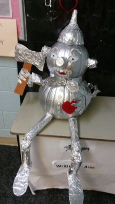 a silver tinsel doll sitting on top of a desk