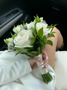 a person in a car holding a bouquet of flowers