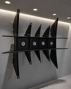 there are five black speakers hanging on the wall