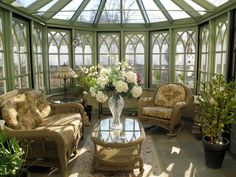 a sun room with wicker furniture and flowers in the vase on the coffee table