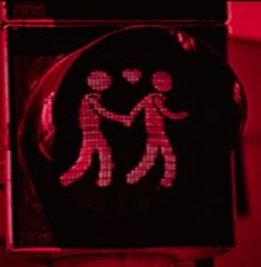 a red traffic light with an image of two people holding hands