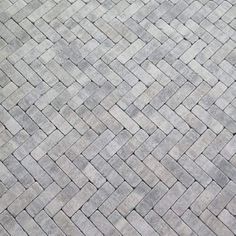 a close up view of a gray brick sidewalk with white and black lines on it