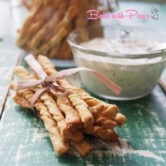 some kind of cracker with a bow on it next to a bowl of dip