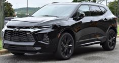 a black chevrolet suv is parked on the street