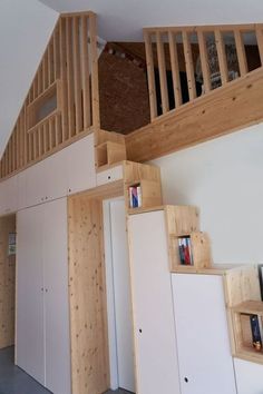 a room with some bookshelves and cabinets under the stair case in front of it