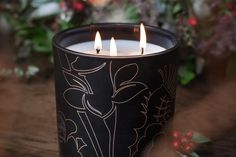 three lit candles sitting on top of a wooden table