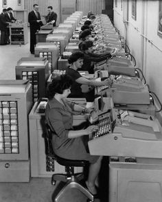 an old photo of women working at computers in a room filled with desks and filing cabinets