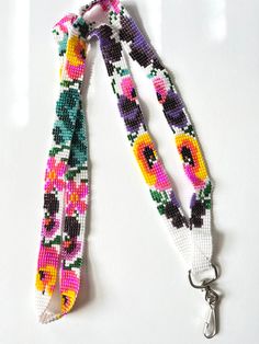 two lanyards with flowers on them are hanging from a keychain that is attached to a white surface