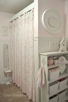 a pink and white bathroom with floral shower curtain