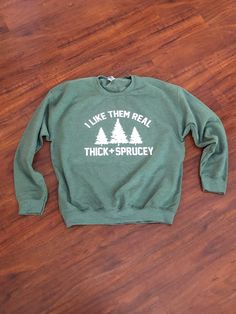 I Like Them Real Thick and Sprucy Crewneck-  Holiday Sweatshirt, Christmas sweatshirt, Funny sweatshirt, funny shirt, funny gift L I S T I N G:   Thanks for checking out our I like them real thick and Sprucy Crewnecks!  Warm up during the cold season and turn heads in the warm sweatshirt or get it as a gift for someone.  I know you are singing the rest of the song out loud.   *  Unisex sizing C A R E We recommend you turn them inside out and wash in COLD water and tumble dry LOW.  Iron if needed Christmas Sweater Outfits, Outdoorsy Style, Christmas Party Outfits, Holiday Sweatshirt, Shirt Quilt, Sweatshirt Christmas, Funny Sweatshirts, Cold Season, Low Iron